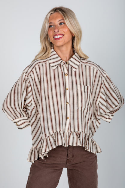 Woman wearing a striped blouse with a plain background