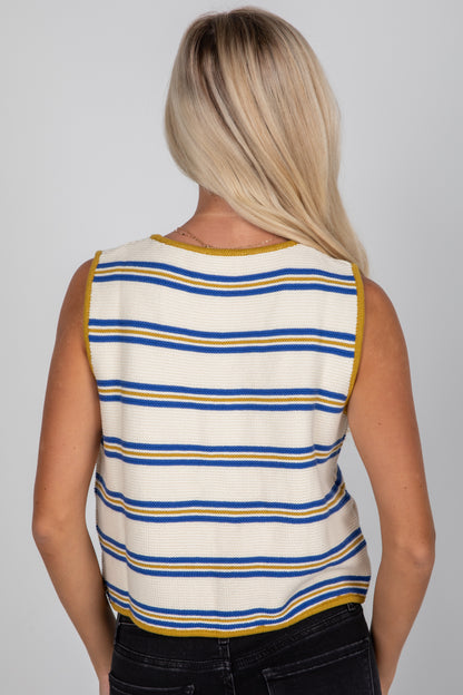 Person wearing a sleeveless striped shirt with blue and yellow stripes on a gray background