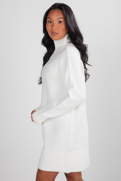 Woman wearing a white turtleneck dress against a plain background