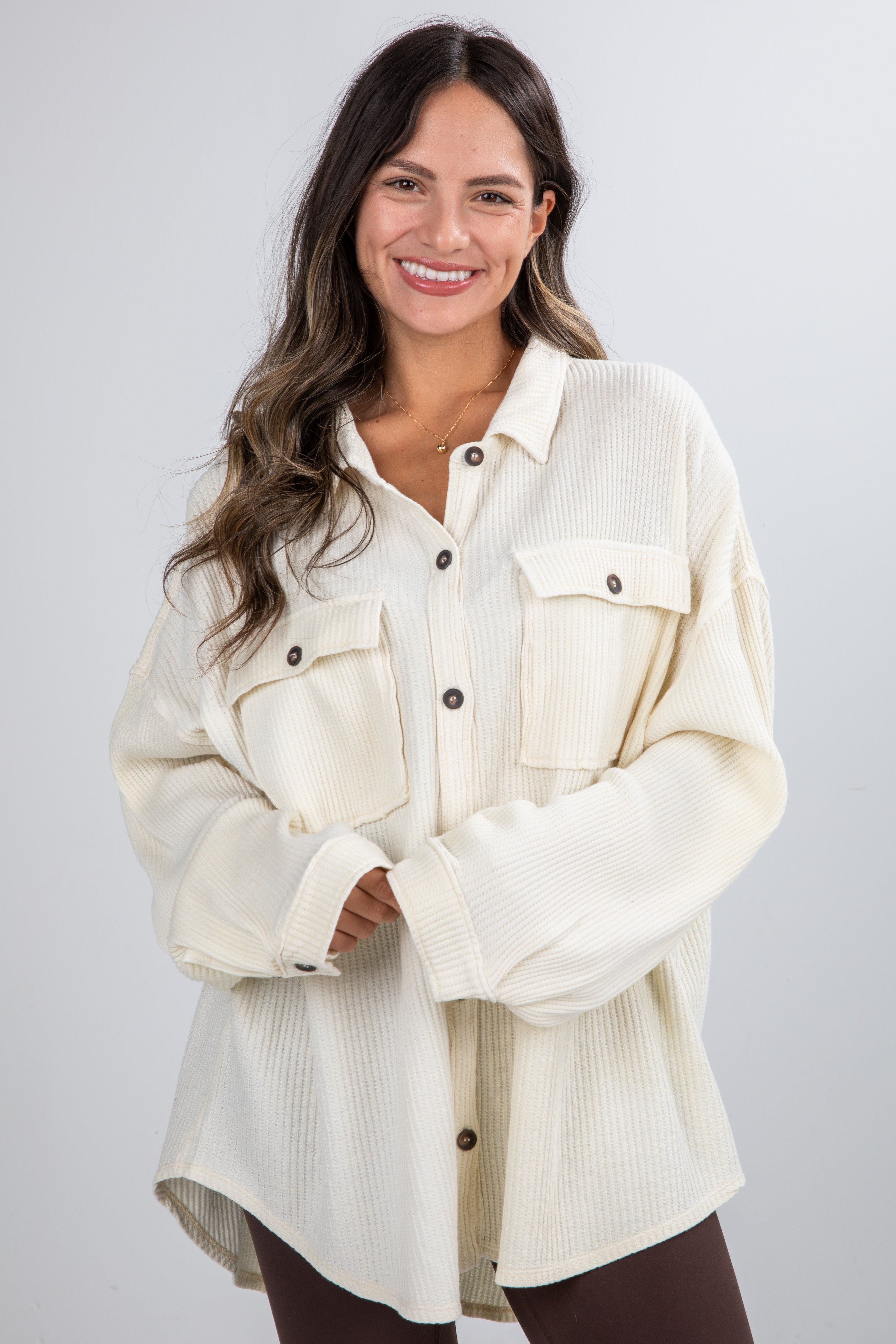 Woman wearing a cream-colored denim jacket on a white background