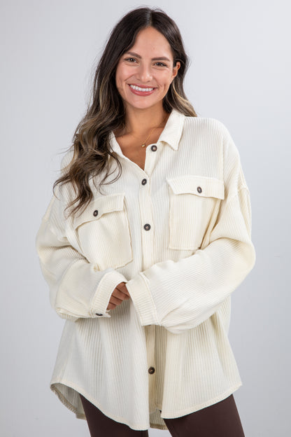 Woman wearing a cream-colored denim jacket on a white background