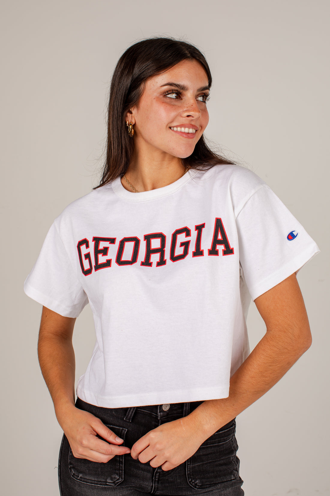 A woman wearing a white cropped t-shirt with &