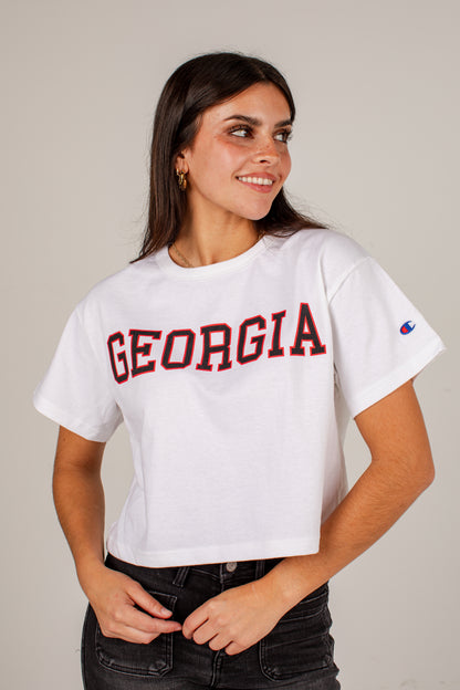 A woman wearing a white cropped t-shirt with &