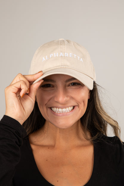 Woman wearing a beige cap with &