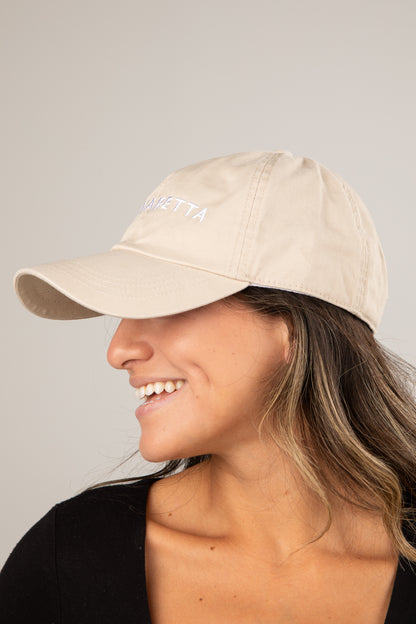 Woman wearing a beige cap with &