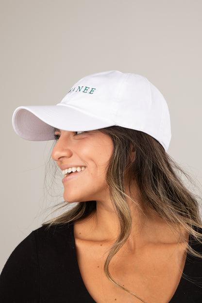 Woman wearing a white cap with text on a neutral background