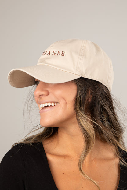 Woman wearing a beige cap with &