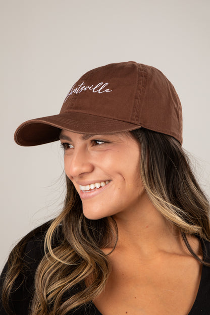 Woman wearing a brown cap with &