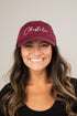 Woman wearing a maroon cap with &