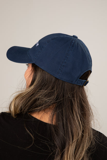 Person wearing a navy blue baseball cap against a plain background