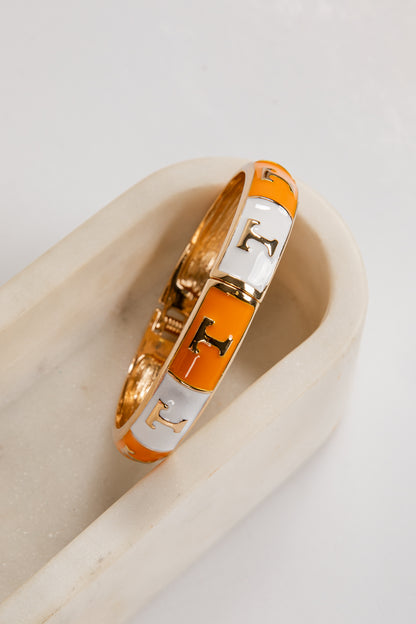 Bracelet with orange and gold design on a light background