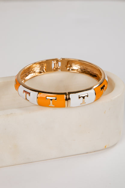 Bangle with orange and white pattern on a light background