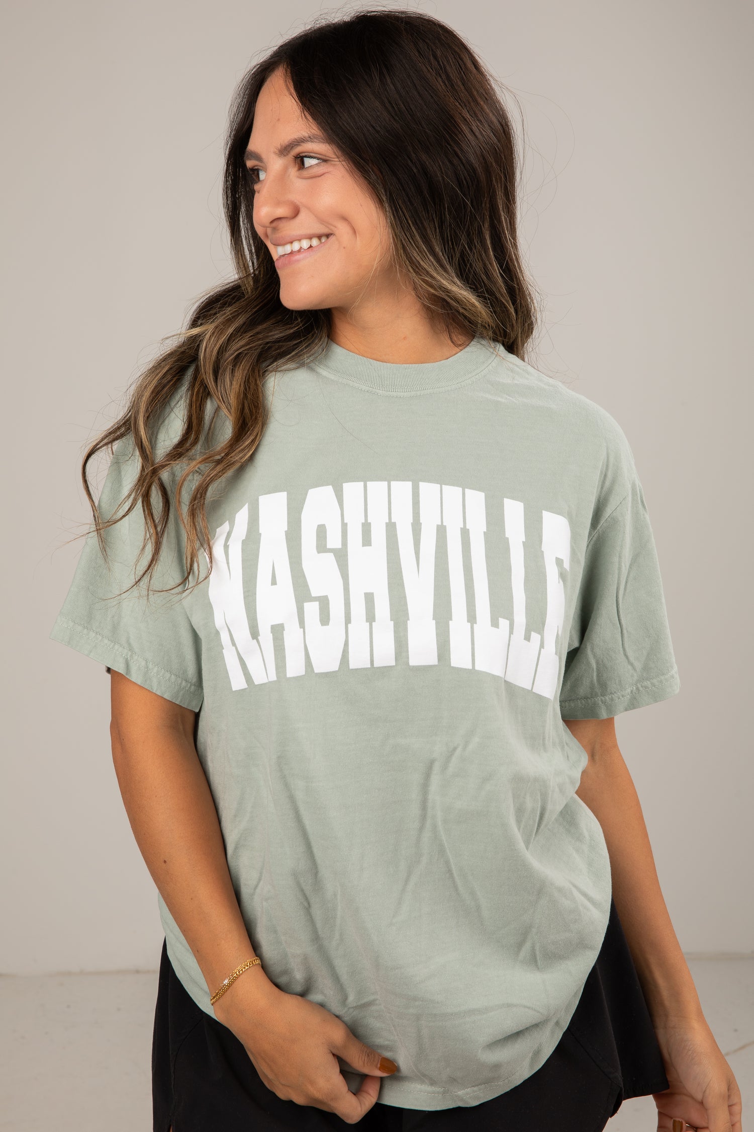 Woman wearing a green t-shirt with &