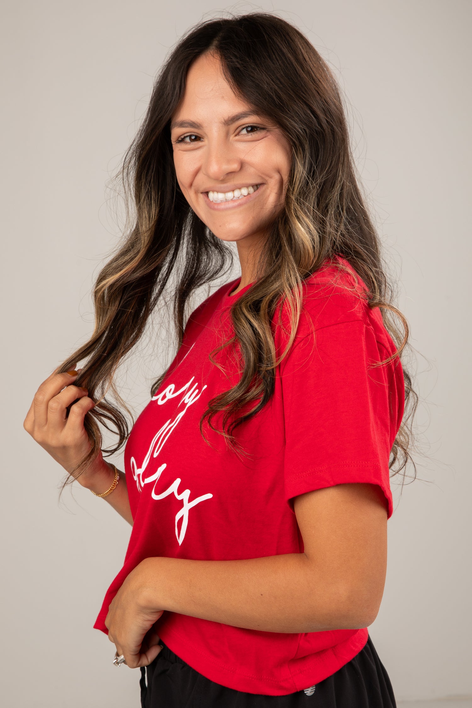 Woman wearing a red t-shirt with white text against a plain background