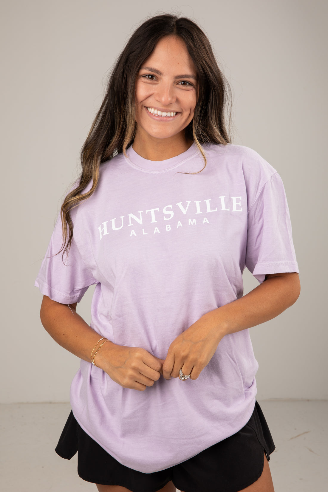 Woman wearing a lavender t-shirt with &