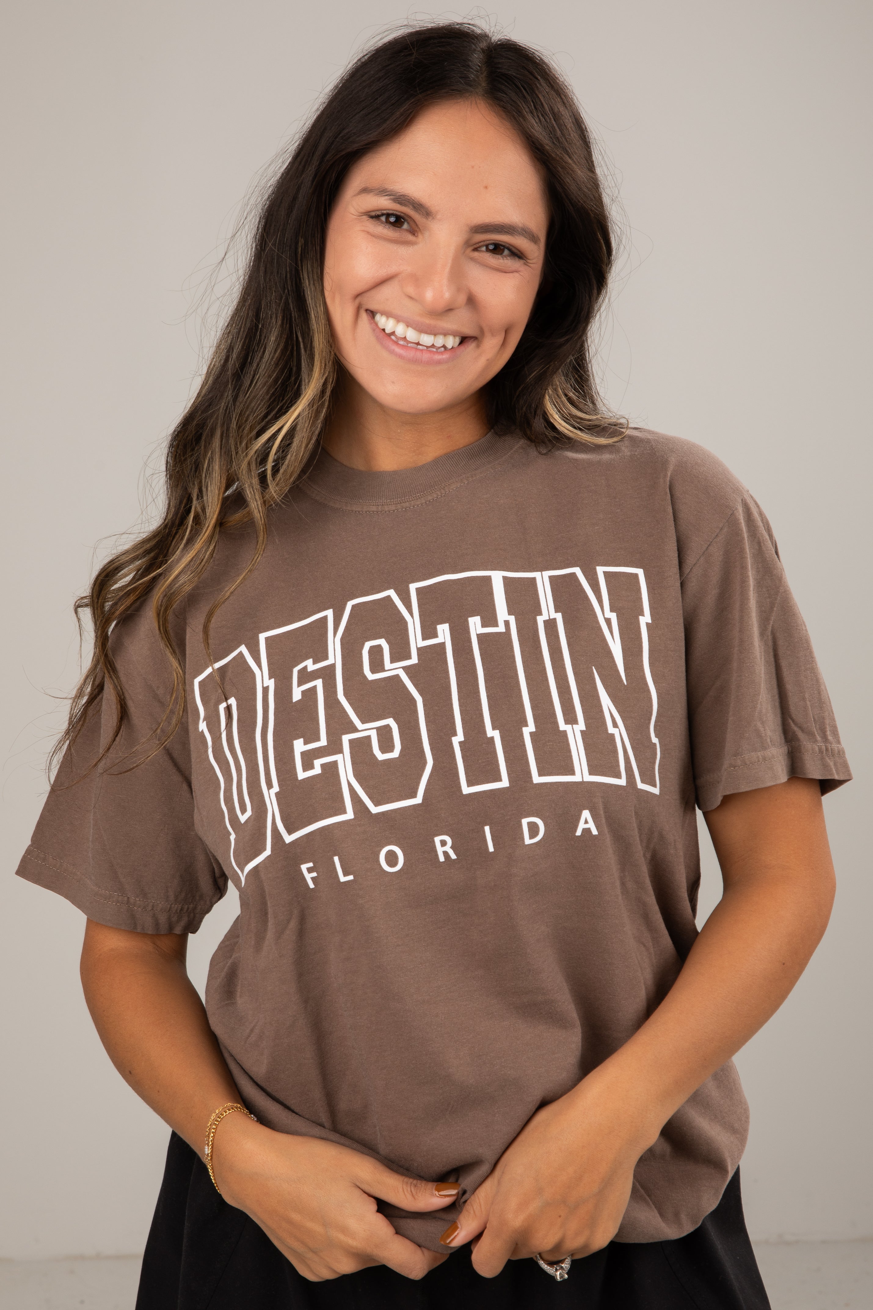 Woman wearing a brown t-shirt with &