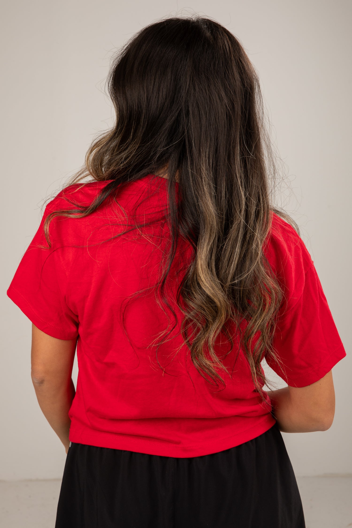 Person wearing a red shirt with a neutral background