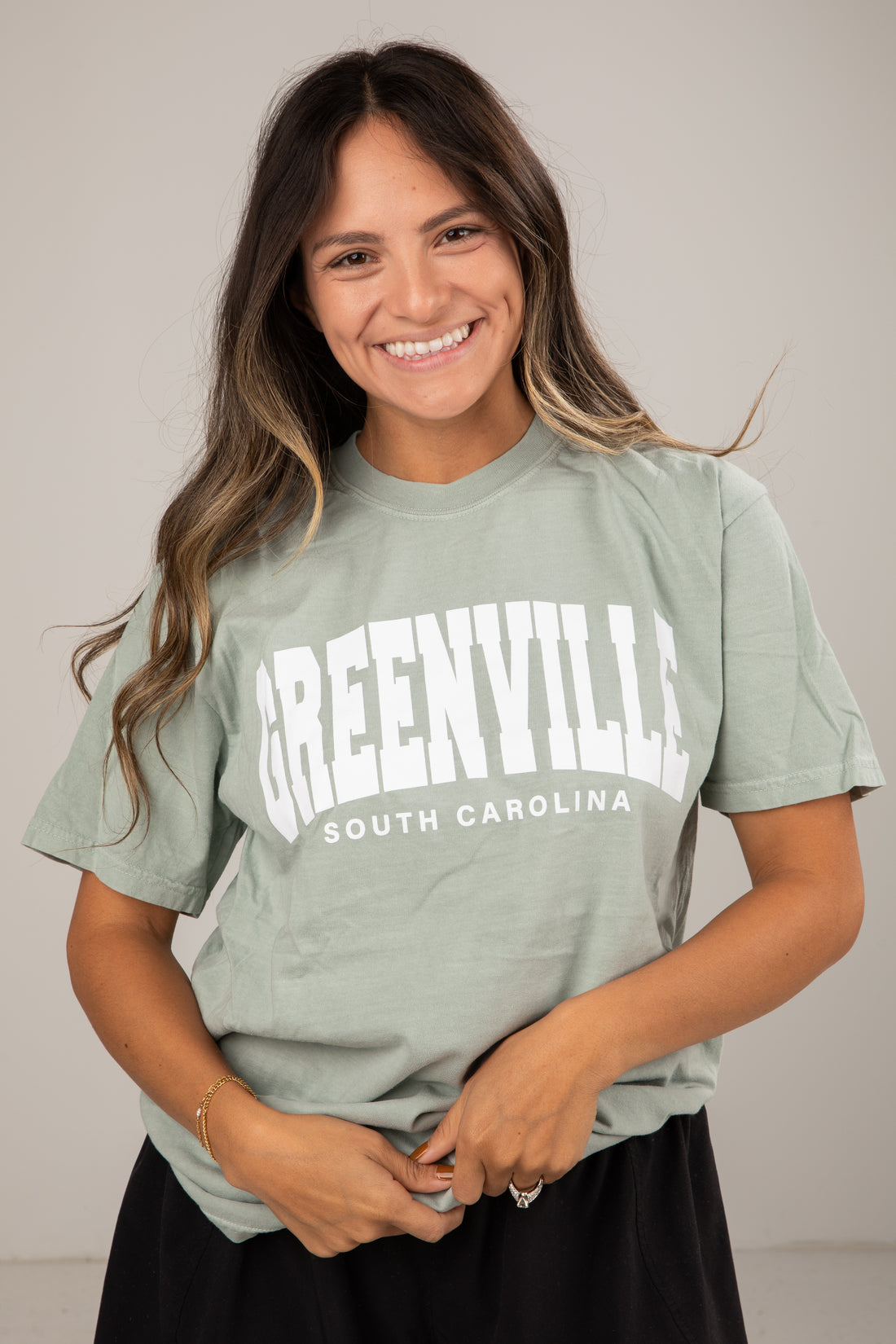 Woman wearing a green t-shirt with &
