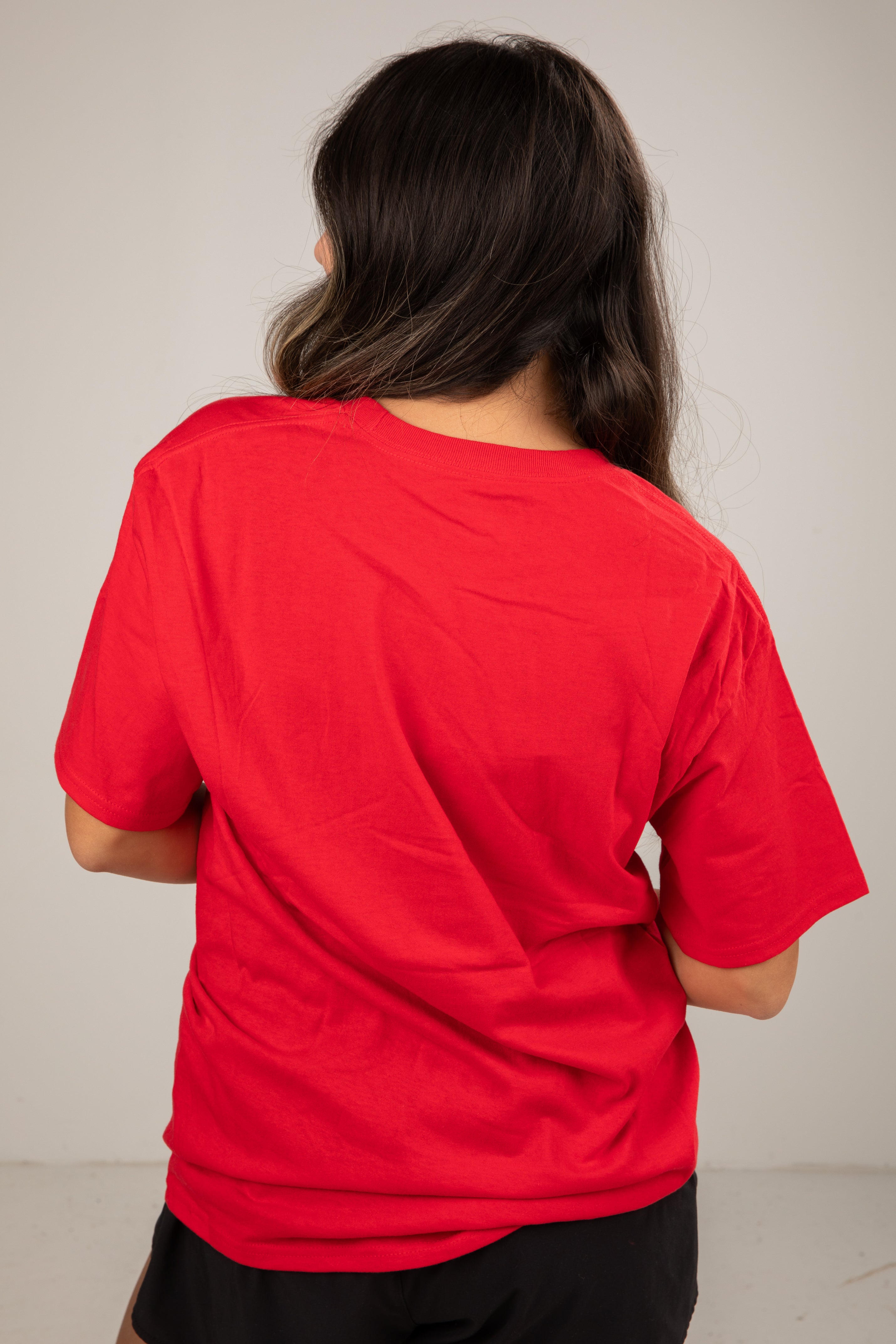 Person wearing a red shirt from behind on a plain background