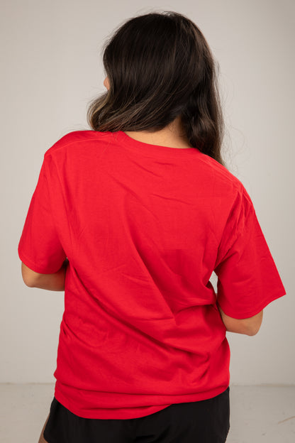 Person wearing a red shirt from behind on a plain background