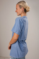 Woman wearing a blue oversized t-shirt against a plain background