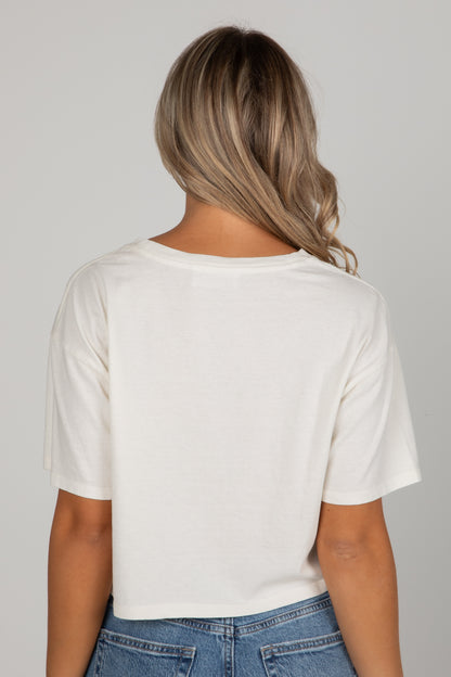 Person wearing a white t-shirt and blue jeans on a plain background