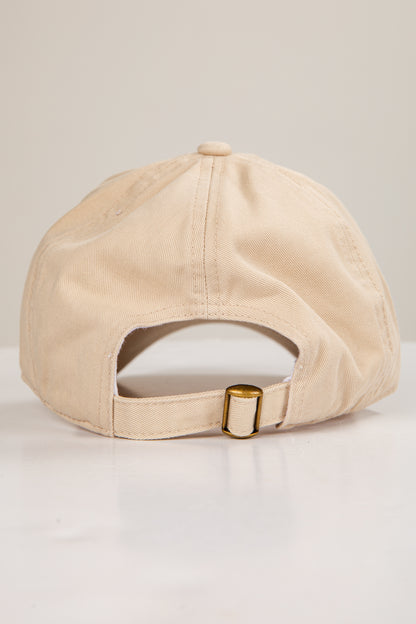 Beige cap with a gold buckle on a light gray background