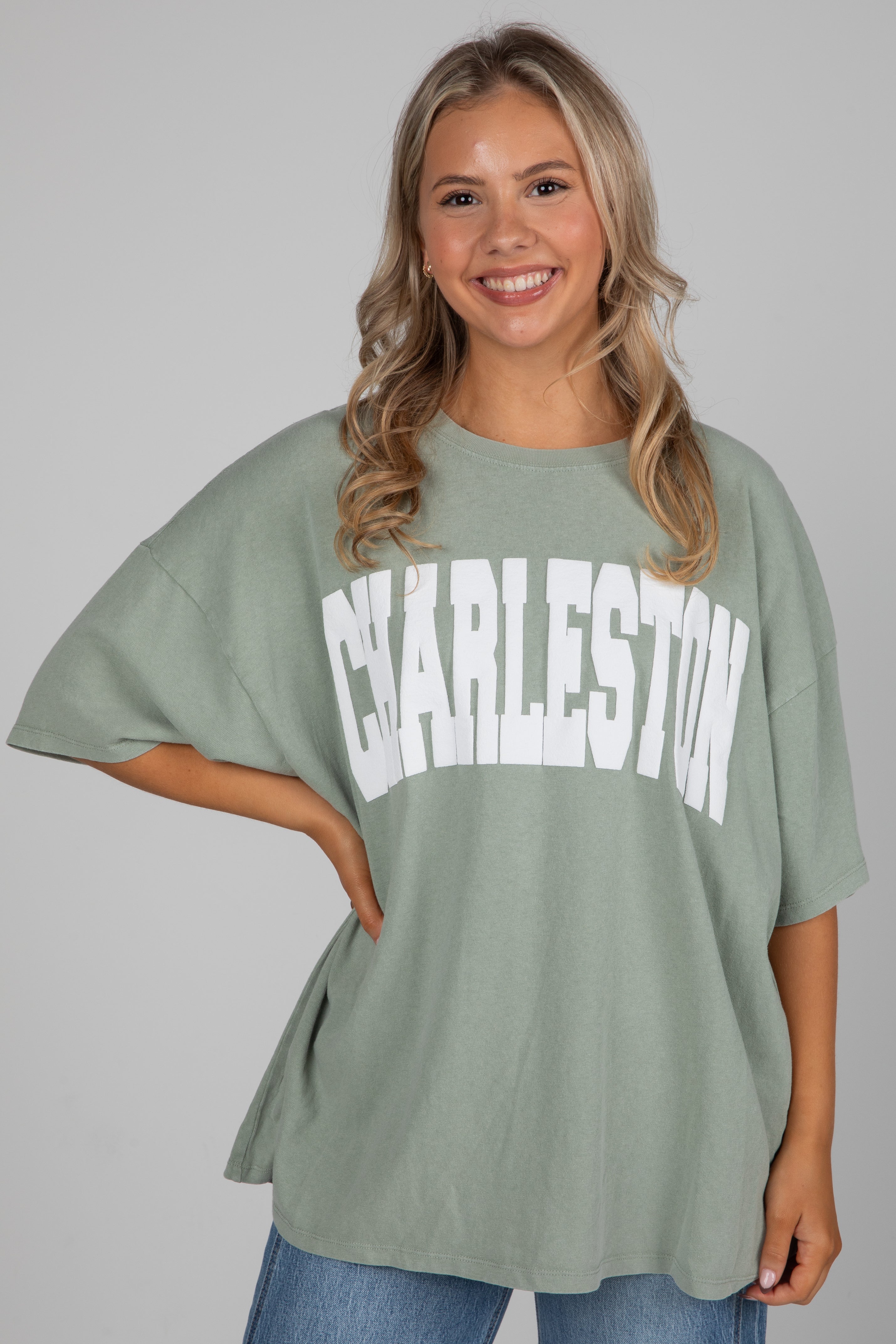 Woman wearing a green oversized t-shirt with &