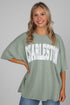 Woman wearing a green oversized t-shirt with &