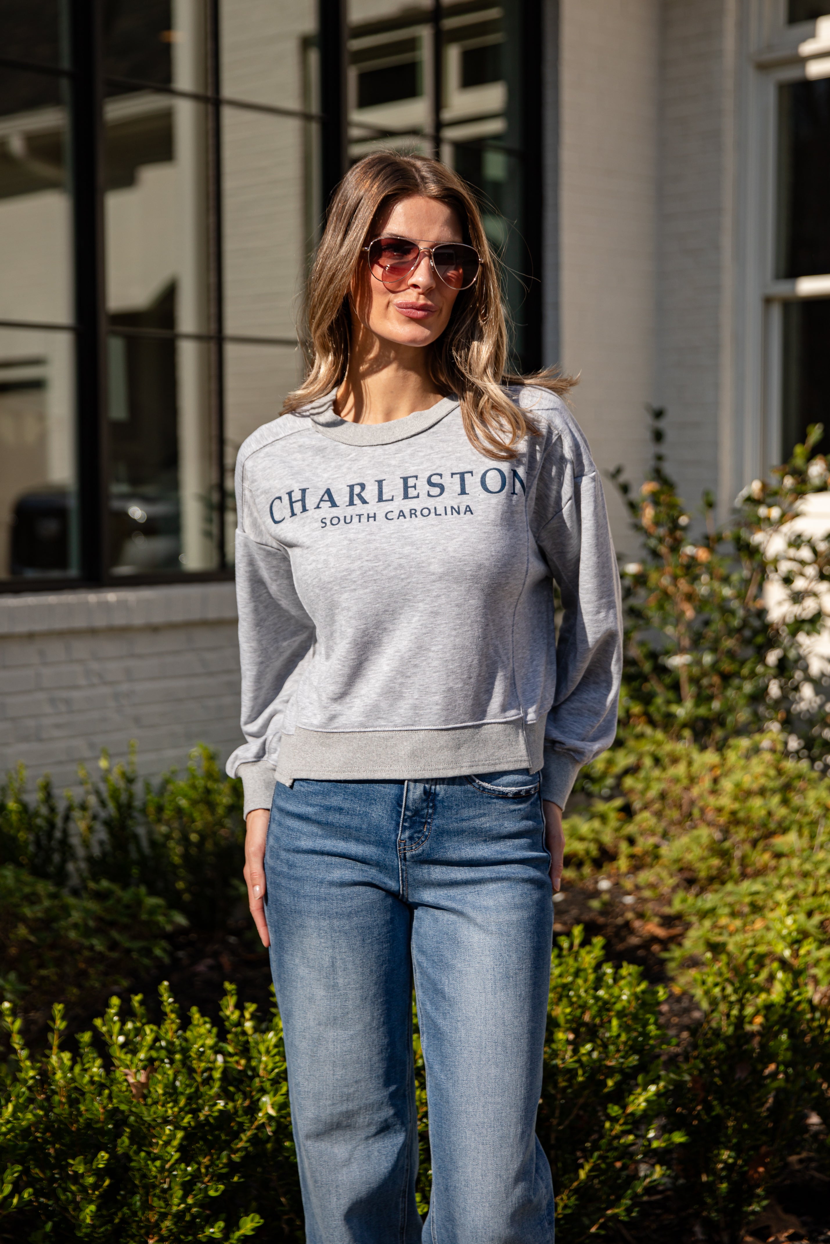 Woman wearing a gray sweatshirt with &