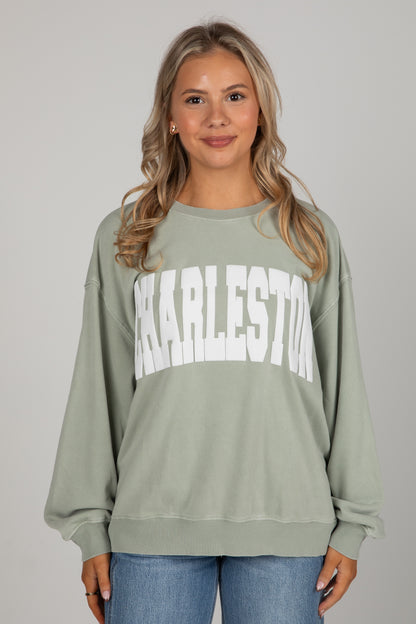 Woman wearing a green sweatshirt with &