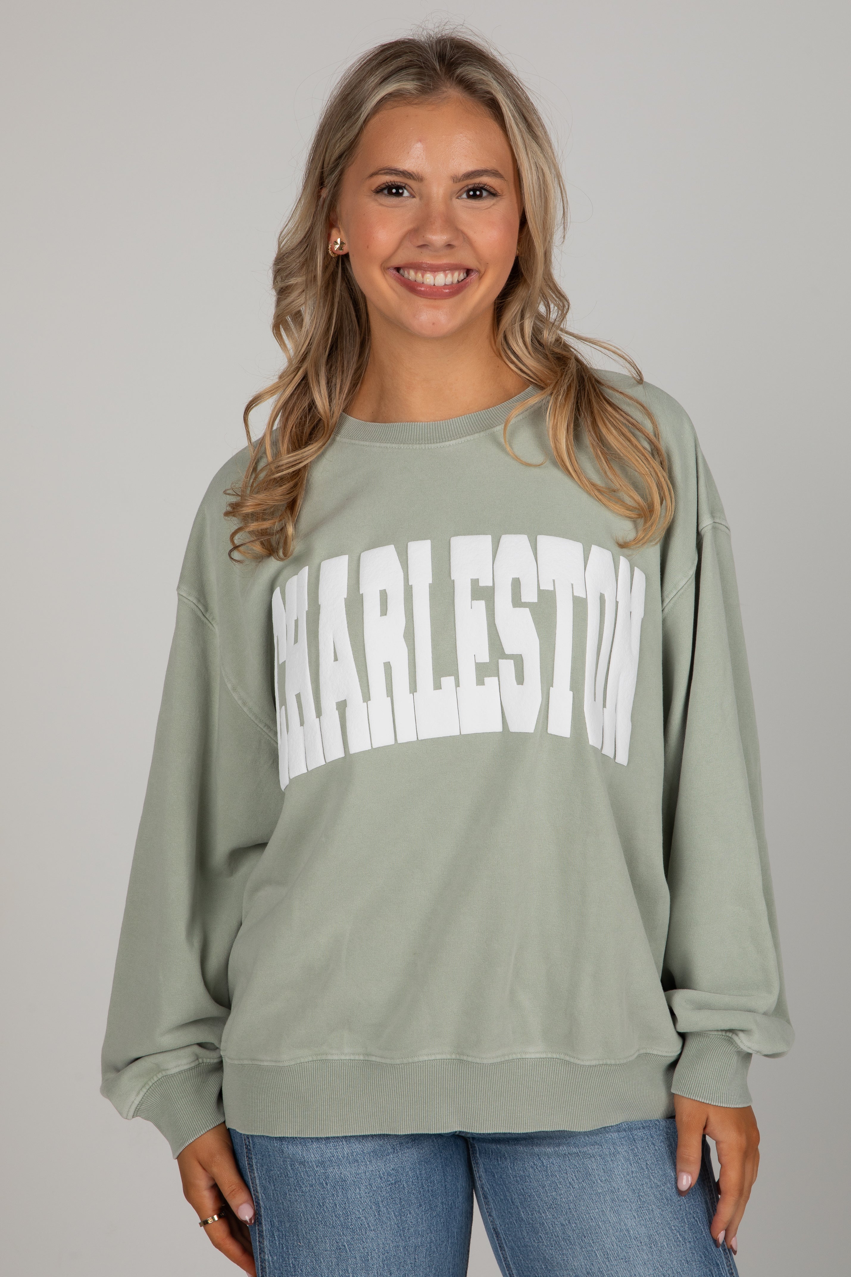 Woman wearing a green sweatshirt with &