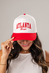 Person wearing a white and red cap with &