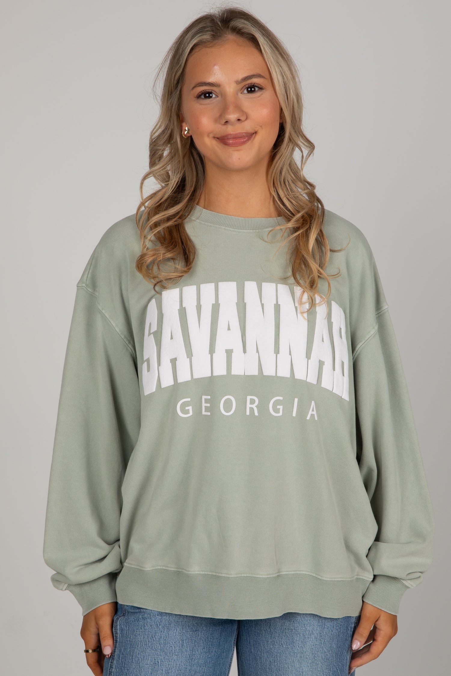 Woman wearing a green sweatshirt with &