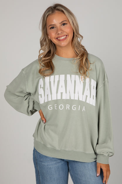 Woman wearing a green sweatshirt with &