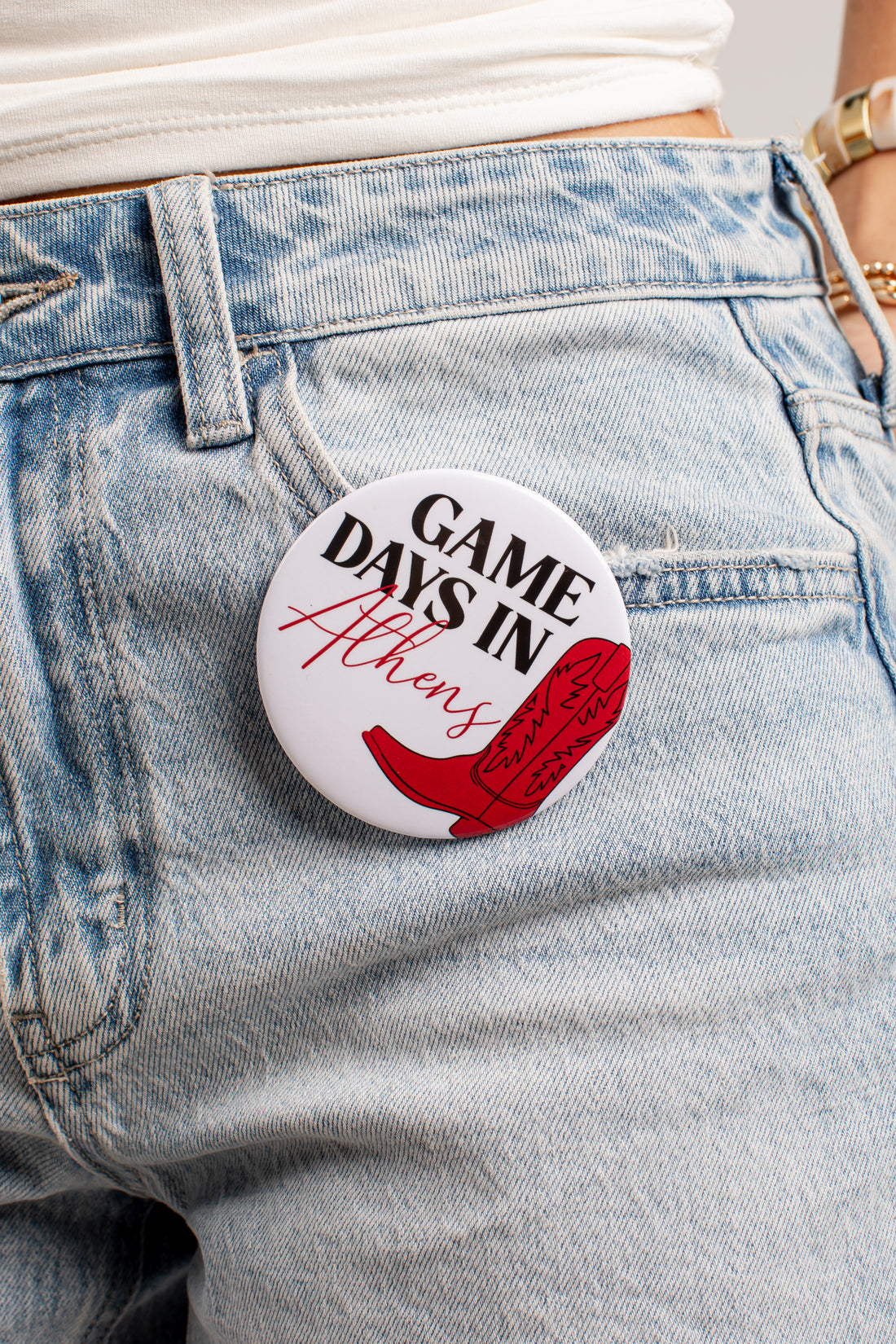 A round pin-back button badge with the text &