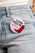 A round pin-back button badge with the text &
