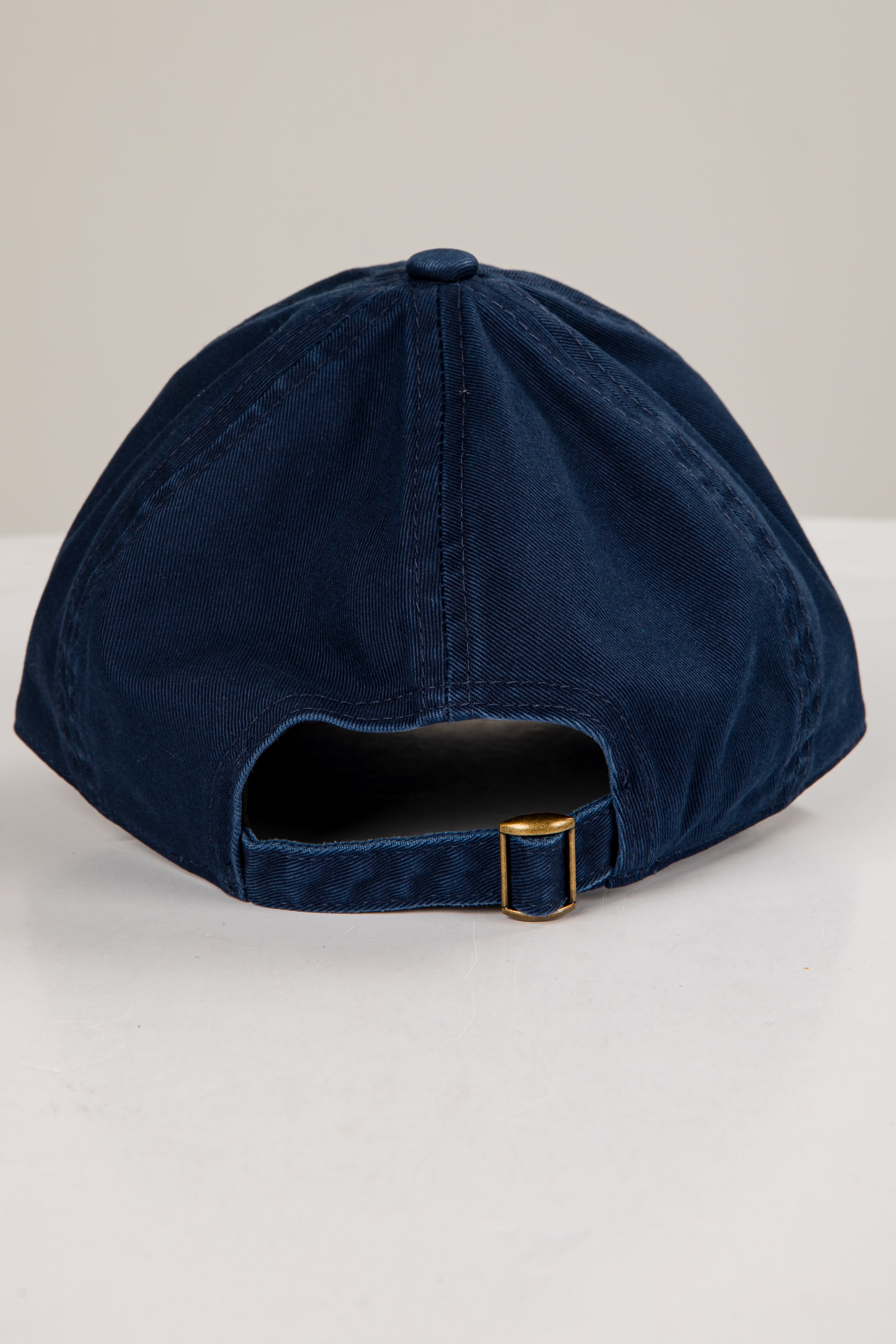 Navy blue cap with a gold buckle on a white background