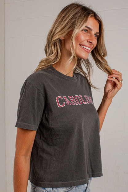 A woman wearing a dark gray washed short-sleeve t-shirt with &
