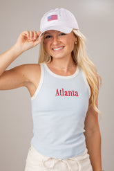 Woman wearing a light blue tank top with &