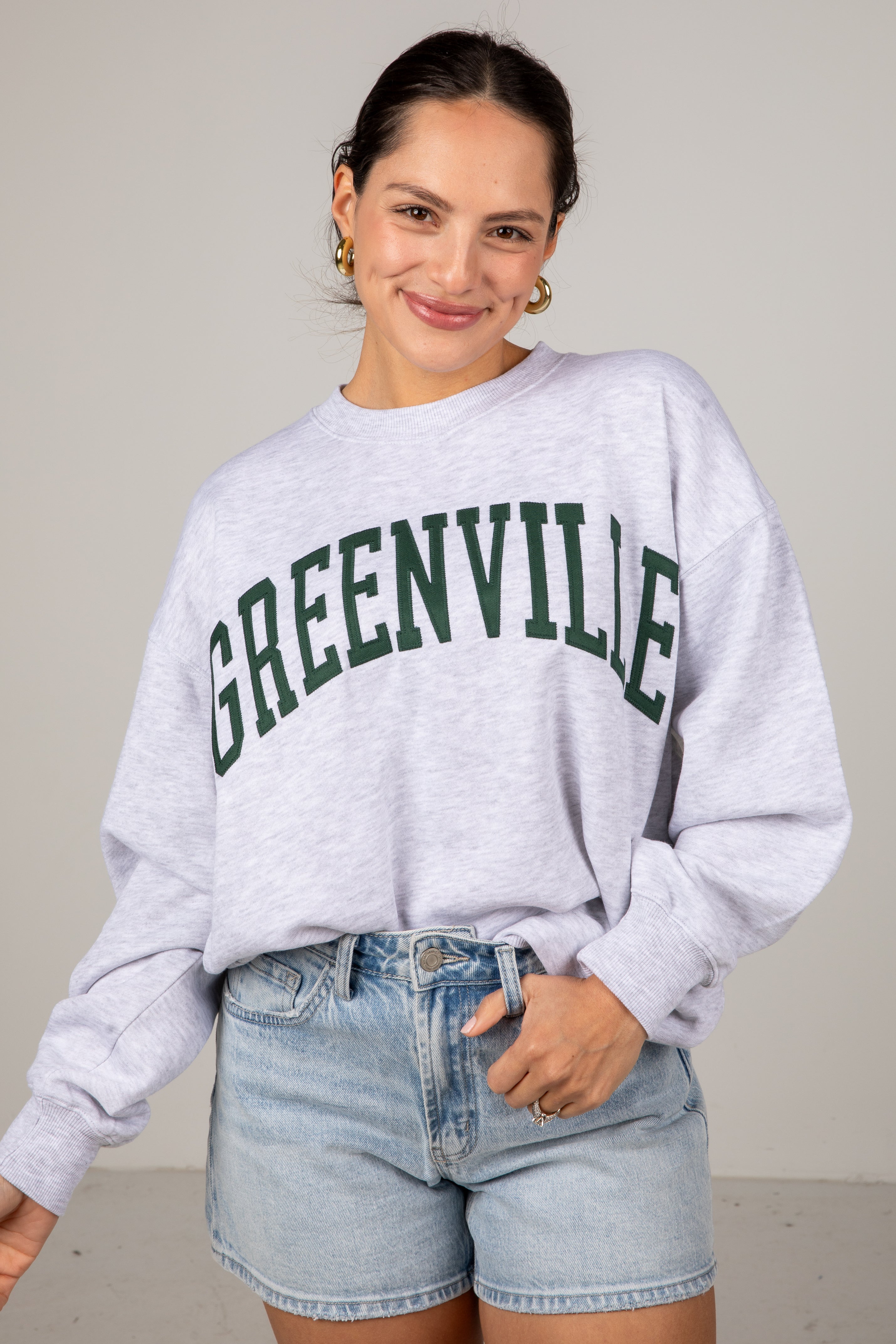 Woman wearing a gray sweatshirt with &