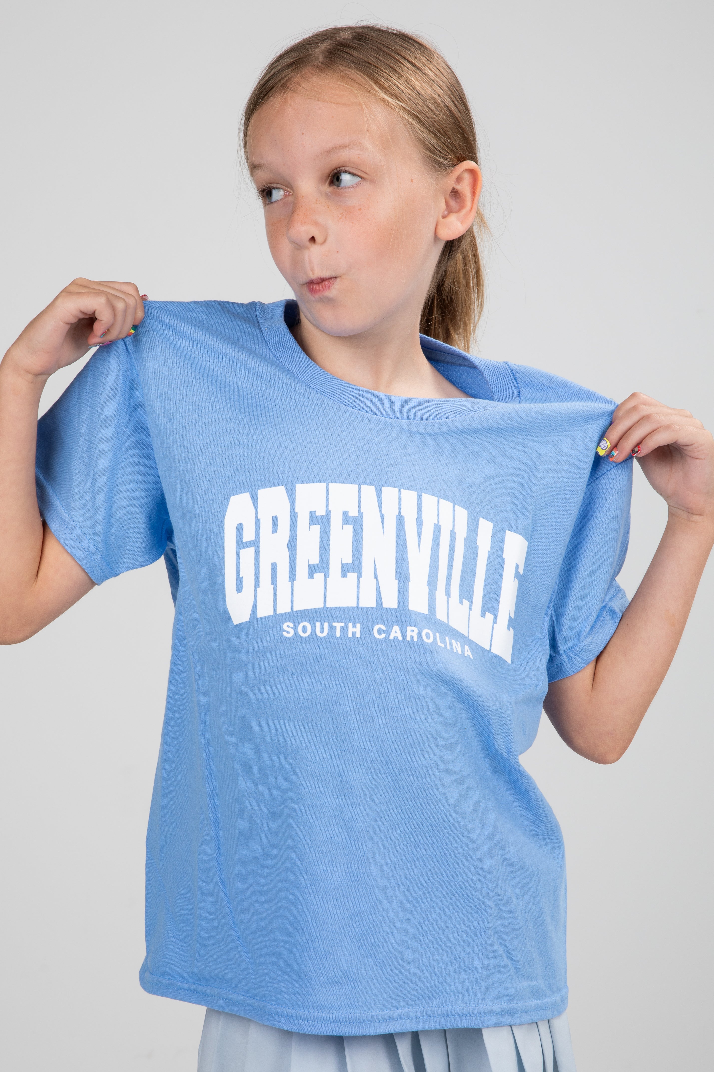 Girl holding a blue t-shirt with &