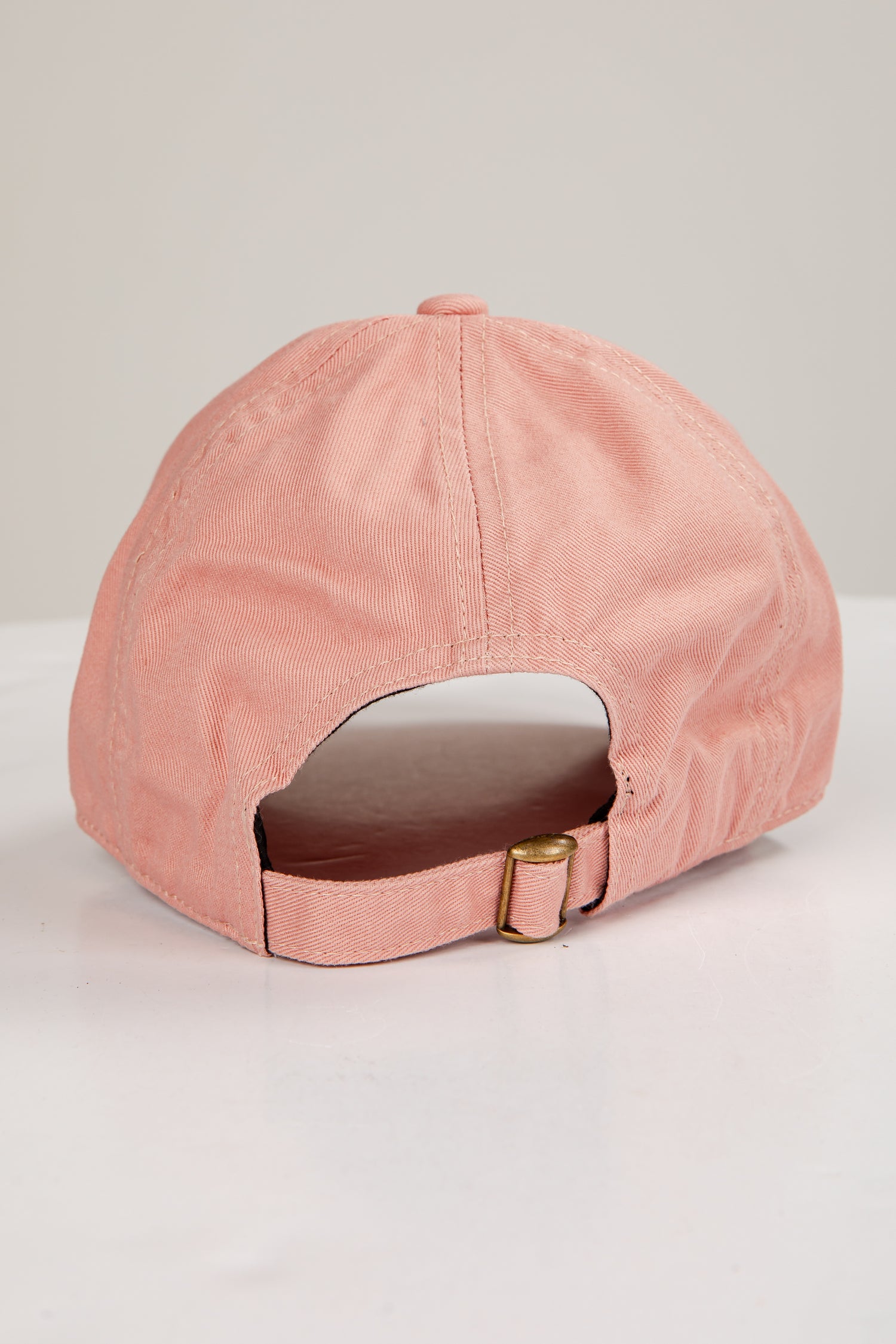 Pink baseball cap on a light gray background