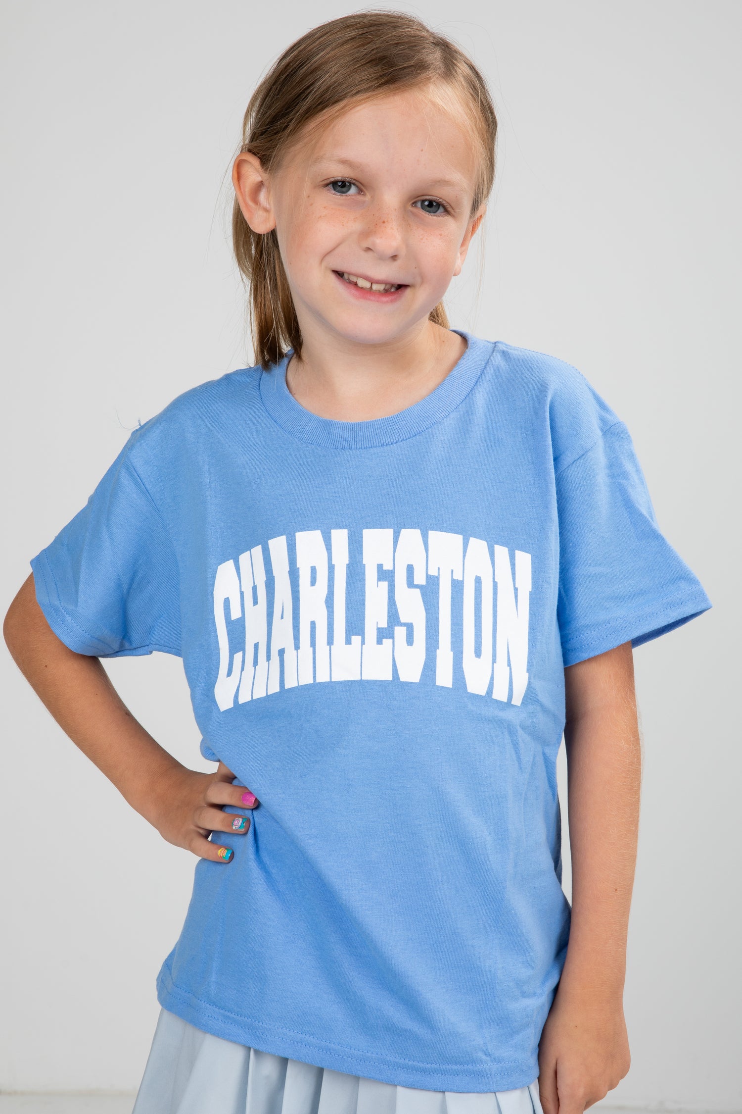 Young girl wearing a blue t-shirt with &
