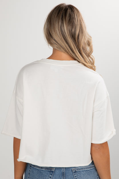 Person wearing a white t-shirt and blue jeans on a plain background