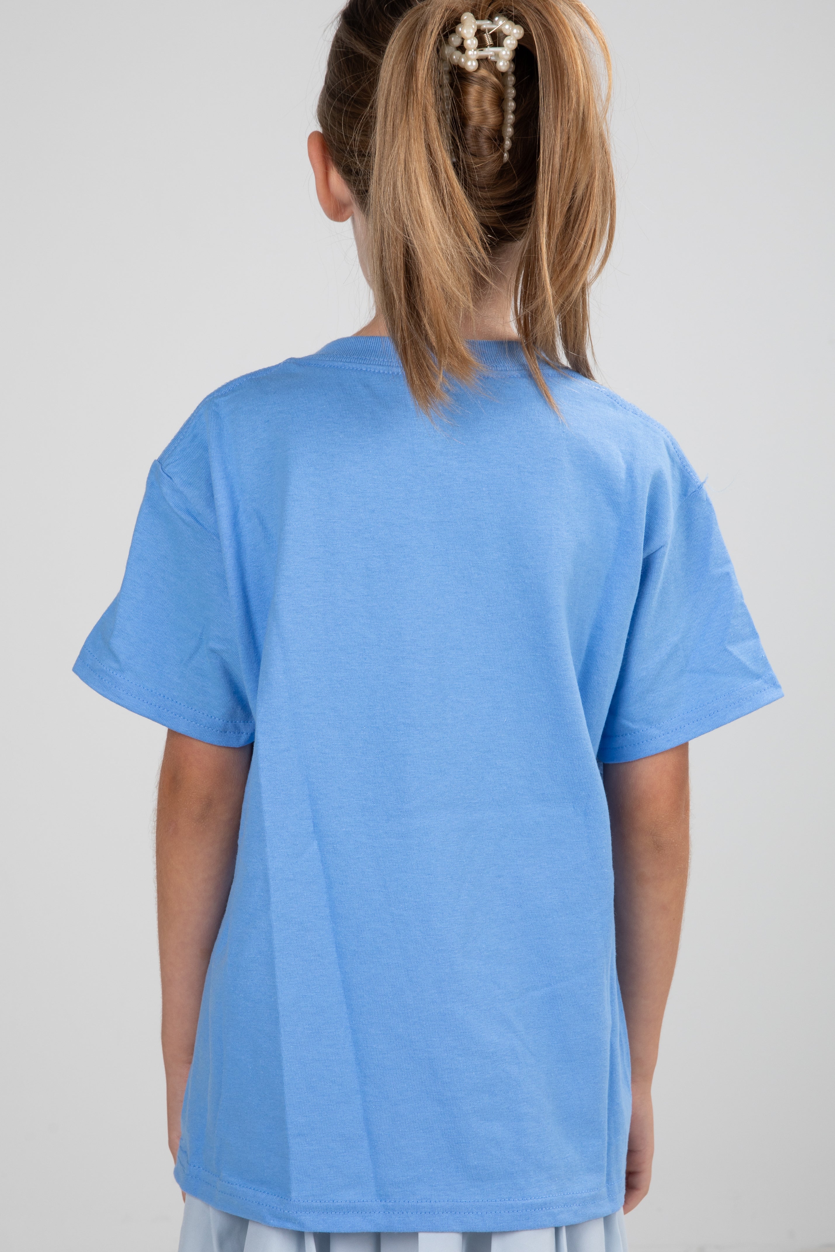 Child wearing a blue t-shirt on a plain background