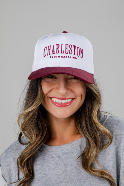 Woman wearing a white and burgundy cap with &
