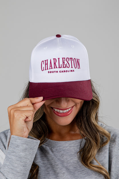 Person wearing a white and burgundy cap with &