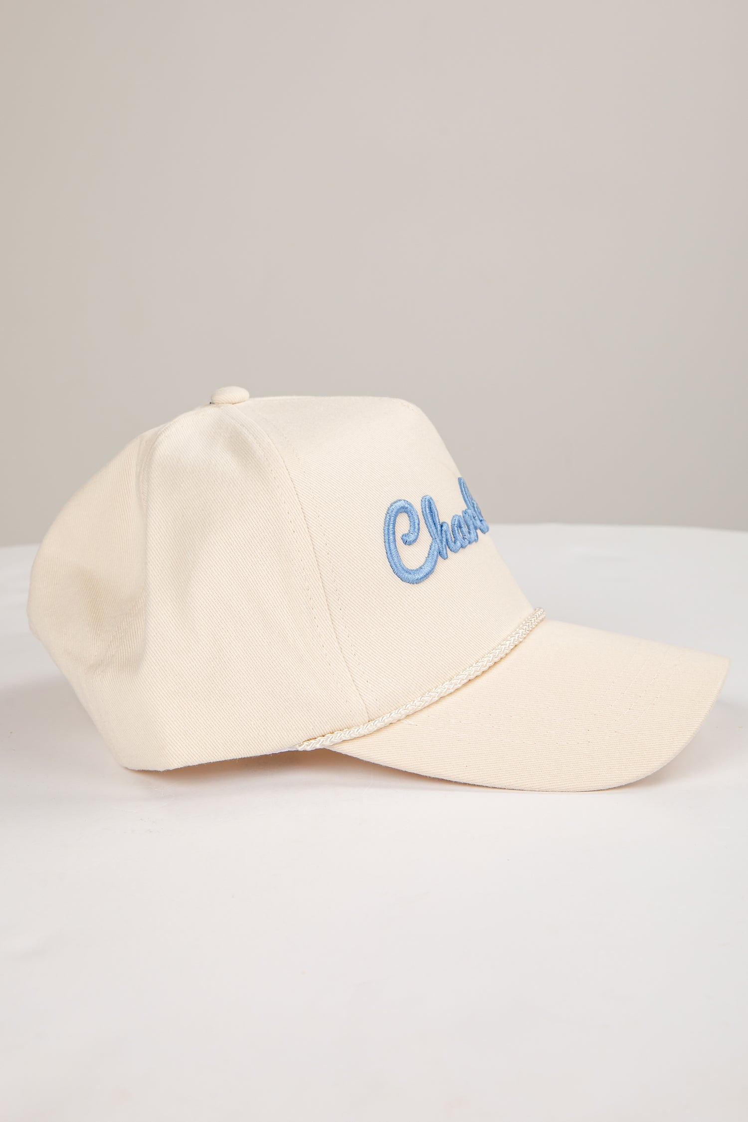 Beige cap with blue text on a light gray background