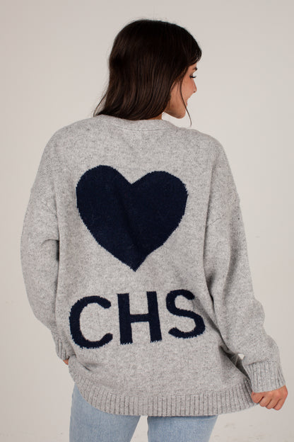 A woman viewed from the back wearing a light heather gray knit sweater with a large dark navy heart and the letters &